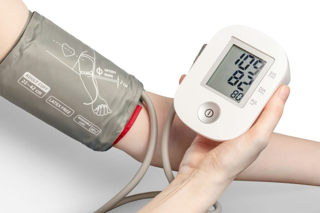 Person using a digital blood pressure monitor cuff on their arm