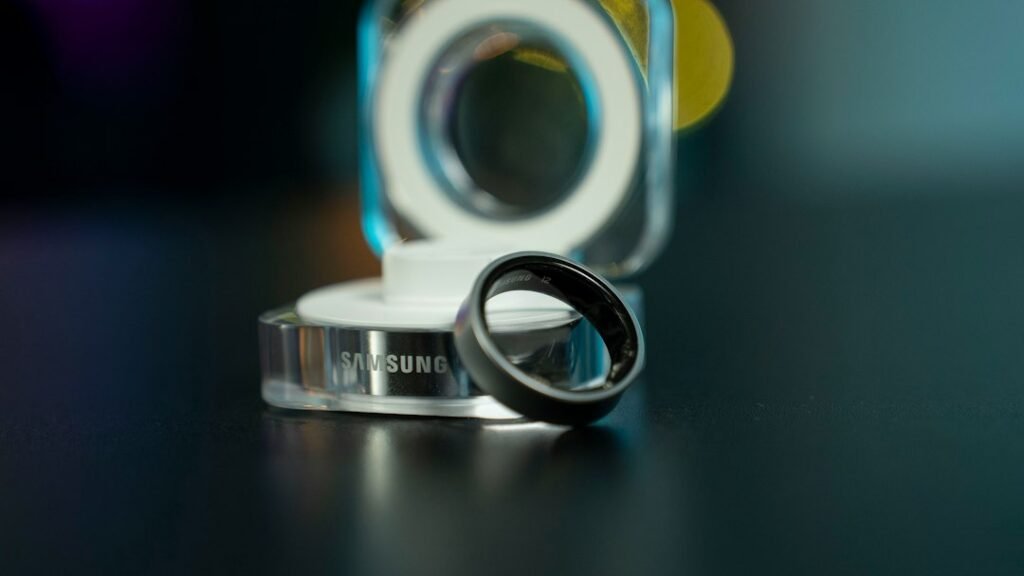 Samsung Galaxy Ring with charging dock next to titanium smart ring